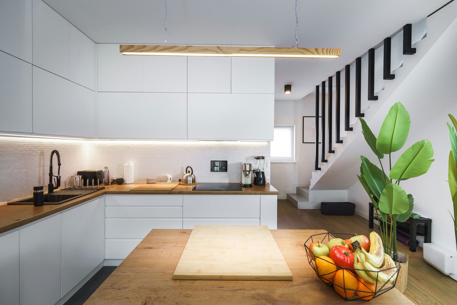 A kitchen with a wooden counter top next to a plant